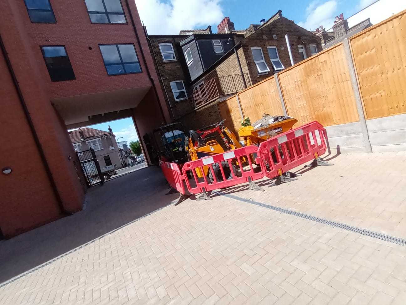 Excavator and dumper neatly stored so as not to restict vehicular access to property