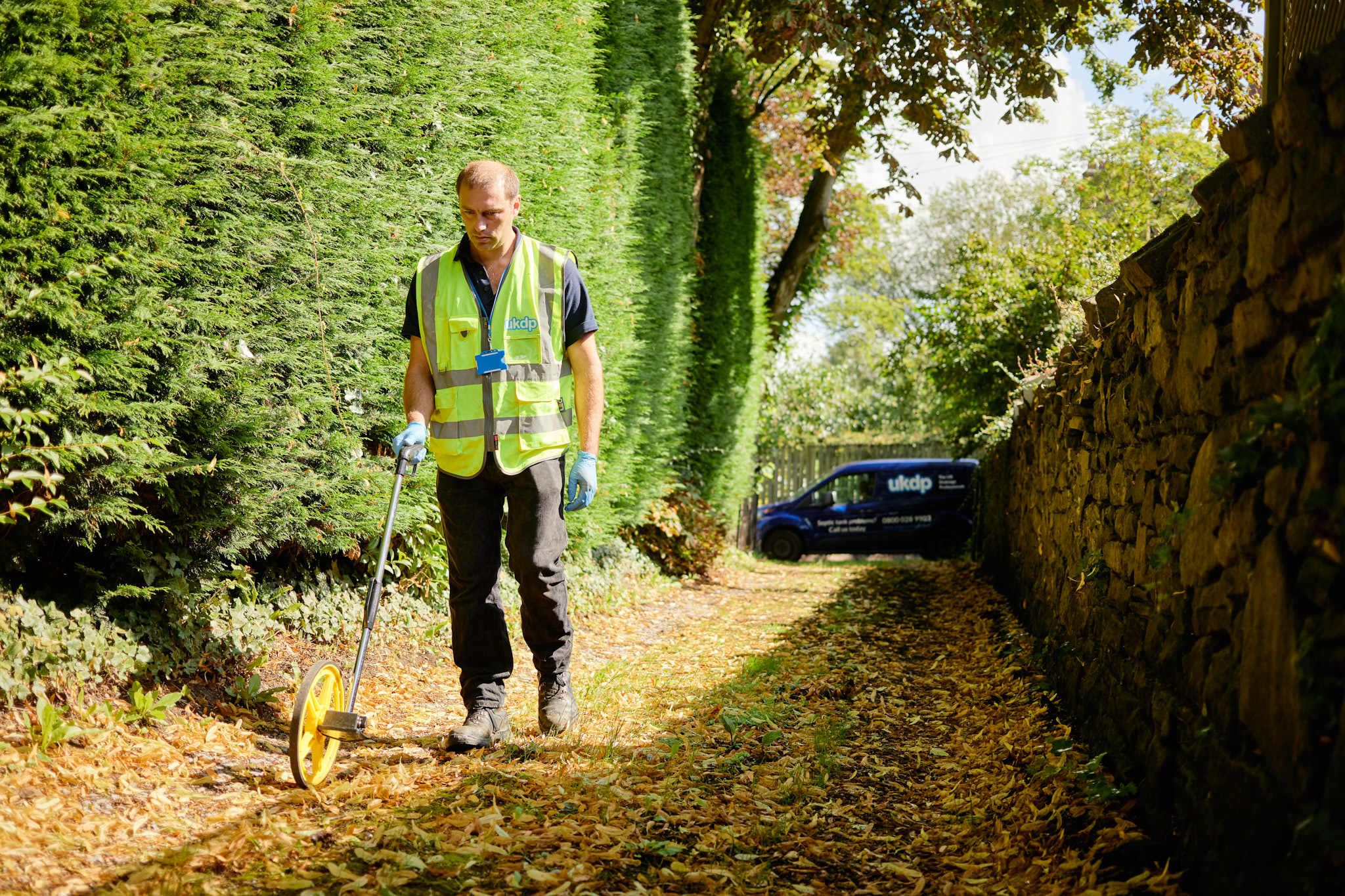 UKDP team member measuring with wheel for drainage system